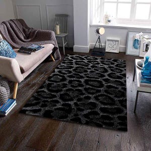 May include: A black and gray leopard print area rug on a dark wood floor. The rug has a plush texture and a repeating pattern of large, irregular spots. The rug is rectangular and covers a significant portion of the floor.