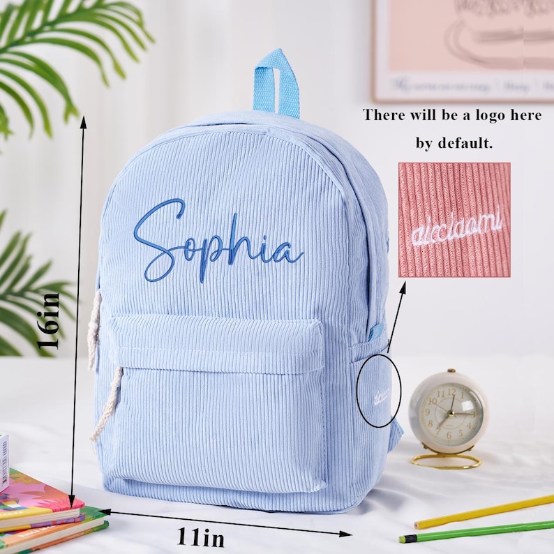 May include: Light blue corduroy backpack with the name "Sophia" embroidered in cursive. The backpack is 16 inches tall and 11 inches wide. It has a front pocket and a top handle. The text "There will be a logo here by default" is also visible.