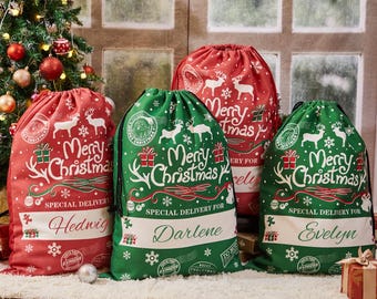 Può includere: Quattro sacchetti regalo di Natale personalizzati in tessuto verde e rosso. I sacchetti presentano un design bianco con il testo "Buon Natale" e un'illustrazione di renna. Ogni sacchetto ha un nome stampato: Hedwig, Darlene, Evelyn e "Buon Natale".