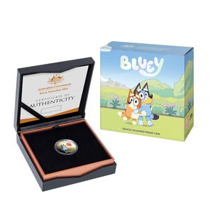 Puede incluir: Una caja negra con un certificado de autenticidad para una moneda de prueba de color australiana de 2024 de 1 $ con el diseño de Bluey. La moneda presenta a Bluey y Bingo abrazándose. La caja está abierta y la moneda es visible en el interior.