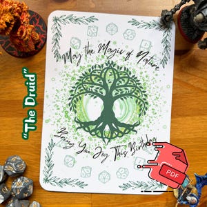 May include: A white card with a green tree design and the text "May the Magic of Nature Bring You Joy This Birthday." The card is decorated with dice and leaf accents. The words "The Druid" are on the left side.