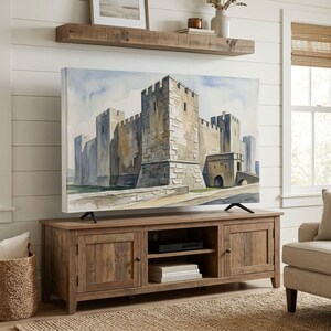 Könnte beinhalten: Ein Flachbildfernseher zeigt ein Aquarellgemälde einer steinernen Burg mit hohen Türmen und befestigten Mauern. Der Fernseher steht auf einem rechteckigen Medienmöbel aus Holz mit zwei Seitenschränken und einem offenen mittleren Regal.