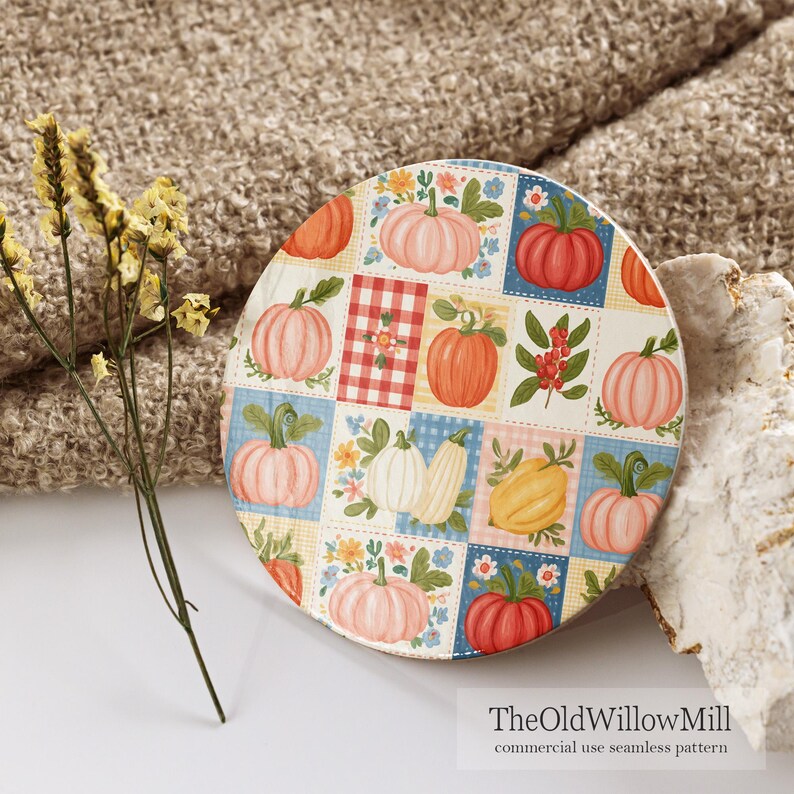 Puede incluir: Un posavasos circular con un patr&oacute;n de cuadr&iacute;cula de calabazas en tonos naranja, rosa, amarillo y blanco, intercalado con motivos florales y cuadros vichy rojos. El texto TheOldWillowMill commercial use seamless pattern es visible.