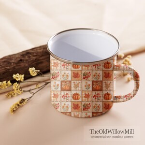 Peut inclure: Un mug en &eacute;mail blanc avec un bord argent&eacute; et une anse, orn&eacute; d'un motif patchwork r&eacute;p&eacute;titif de citrouilles orange, de feuilles d'automne et de fleurs. Le texte "TheOldWillowMill commercial use seamless pattern" est imprim&eacute; en bas.