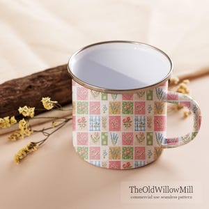 Puede incluir: Una taza de esmalte blanco con borde plateado y asa, que presenta un patr&oacute;n de cuadr&iacute;cula repetitivo de peque&ntilde;os cuadrados con diversas ilustraciones florales en tonos rosa, verde, amarillo y azul. El texto TheOldWillowMill commercial use seamless pattern es visible.