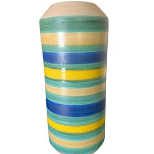 May include: A cylindrical ceramic vase with horizontal stripes in shades of blue, yellow, and green. The top and bottom of the vase are a light beige color. The vase is a decorative item.