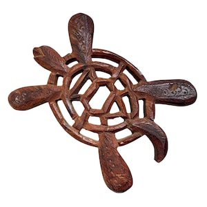 May include: A handcrafted wooden turtle-shaped trivet. The trivet is carved from dark brown wood, featuring intricate details on the head, flippers, and shell. The openwork design allows for heat dissipation, making it suitable for hot dishes. The trivet measures approximately 25 cm in length.