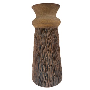 Könnte beinhalten: Eine hohe, braune Keramikvase mit einer strukturierten Oberfläche, die an Baumrinde erinnert. Die Vase hat eine breite Öffnung und einen schmalen Boden.