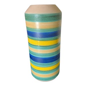 May include: A tall, cylindrical vase with a beige top and a body adorned with horizontal stripes. The stripes alternate between shades of blue, yellow, and green. The vase is approximately 10 inches tall.