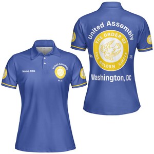 K&ouml;nnte beinhalten: Blaues Poloshirt mit gelben Verzierungen. Es zeigt den Text "United Assembly" und "The Order of the Golden Circle" auf der Vorder- und R&uuml;ckseite. Auf der R&uuml;ckseite steht auch "Washington, DC" und "No. 375".