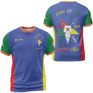 May include: A blue t-shirt with red, yellow, and green accents. The front features text that says "Your Name" and a star emblem. The back displays "Order Of The Eastern Star" and a star design with names.
