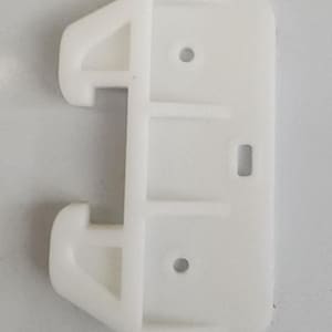 May include: White plastic drawer slide with two holes and a rectangular opening. The slide is designed to be attached to a drawer and a cabinet.