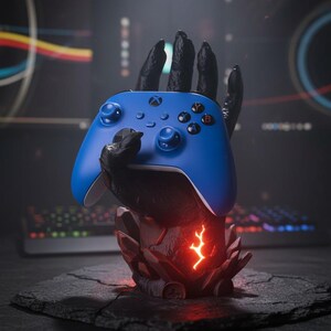 May include: A blue Xbox controller is held by a black, stylized hand-shaped stand. The stand has a red, glowing lightning bolt design. The controller is resting on a dark, textured surface, suggesting a gaming theme.