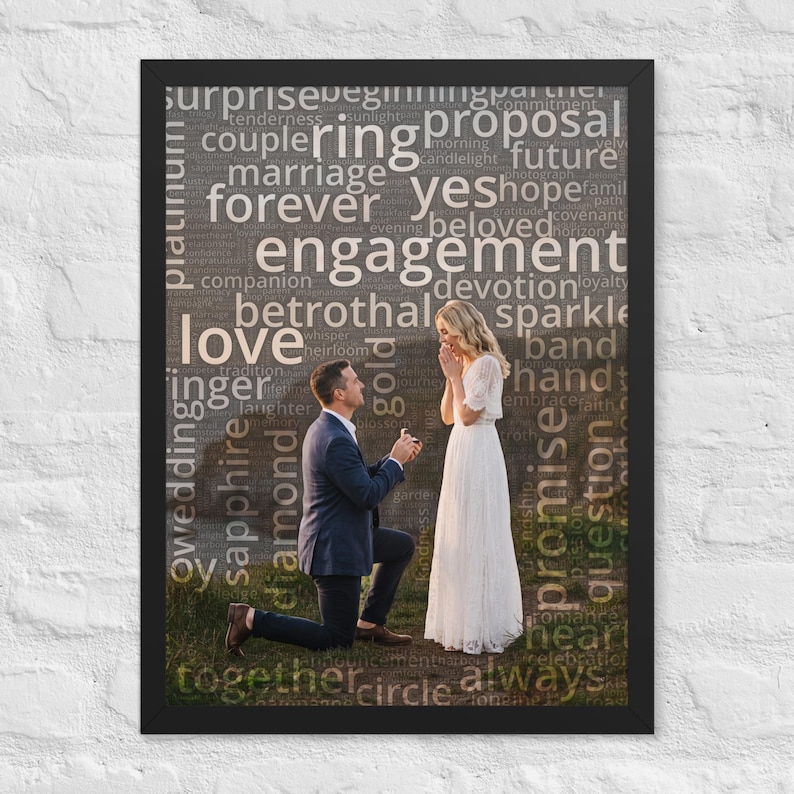 May include: A framed wall art print featuring a photograph of a person in a dark suit kneeling to propose to a person in a white dress. The image is overlaid with a word cloud containing terms like engagement, ring, love, and forever in white text.