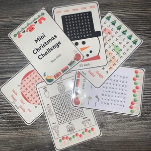 K&ouml;nnte beinhalten: Eine Sammlung von Weihnachtswortsuchkarten. Jede Karte zeigt festliche Illustrationen, darunter einen Schneemann, Weihnachtsb&auml;ume und Ornamente. Die Karten tragen den Text "Mini Christmas Challenge" und "&pound;5 each".