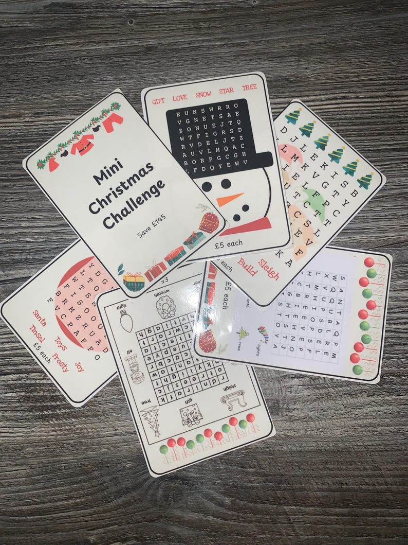 K&ouml;nnte beinhalten: Eine Sammlung von Weihnachtswortsuchkarten. Jede Karte zeigt festliche Illustrationen, darunter einen Schneemann, Weihnachtsb&auml;ume und Ornamente. Die Karten tragen den Text "Mini Christmas Challenge" und "&pound;5 each".