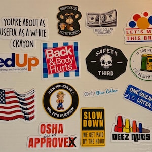 May include: A collection of various stickers with humorous and sarcastic phrases. Designs include a monkey with a coffee cup, a skull, an American flag, and text like "Fed Up" and "Back & Body Hurts."
