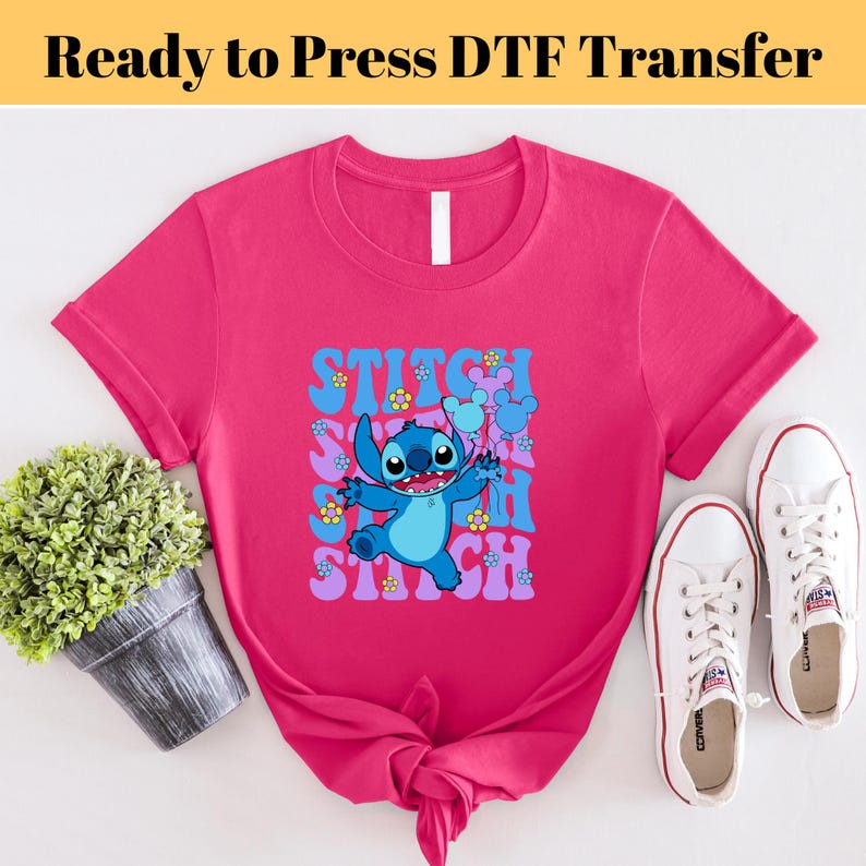 May include: A pink t-shirt with a blue Stitch character holding balloons. The text "Stitch" is repeated in a retro font.
