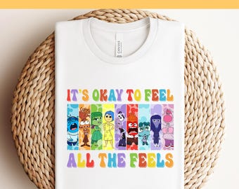 May include: White t-shirt with a colorful graphic of characters from the movie Inside Out. The graphic says "It's okay to feel all the feels".
