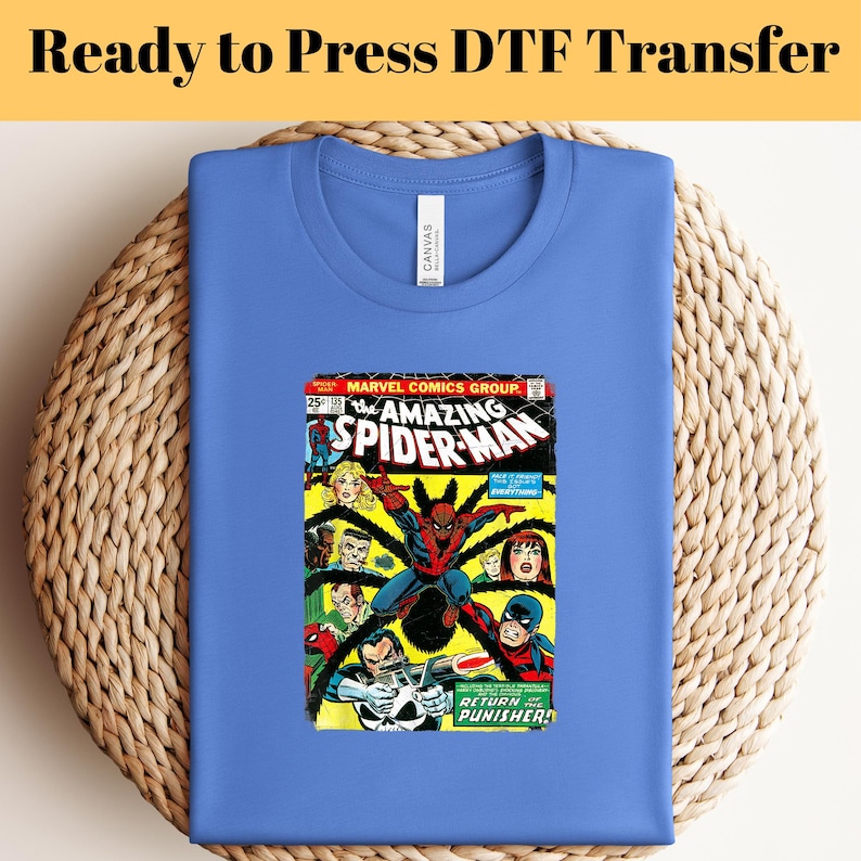May include: A blue t-shirt with a vintage comic book print of The Amazing Spider-Man #105. The comic book cover features Spider-Man in action with the Punisher. The text on the comic book cover reads "The Amazing Spider-Man" and "Return of the Punisher!"