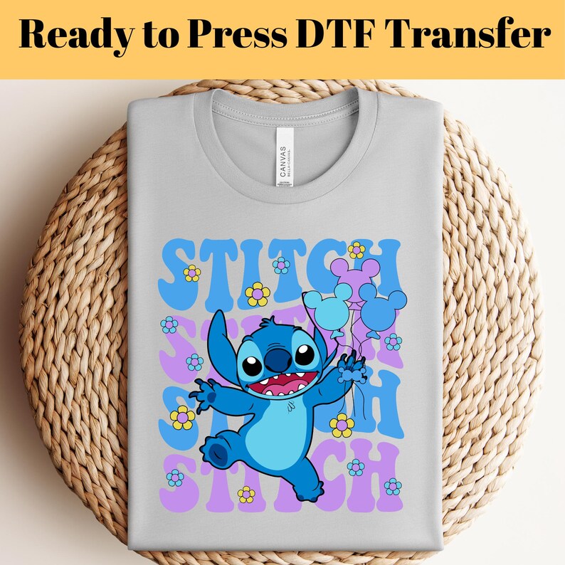May include: A light gray t-shirt with a blue Stitch character holding balloons with Mickey Mouse ears. The text "Stitch Stitch Stitch" is printed in purple and blue letters with yellow flowers.