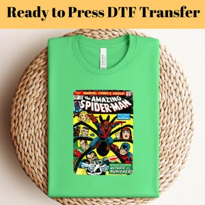 May include: A green t-shirt with a vintage comic book image of Spider-Man on the front. The comic book cover features the text "The Amazing Spider-Man" and "Return of the Punisher!"