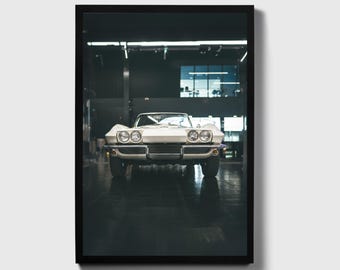 Op de afbeelding: Een witte klassieke Corvette sportwagen geparkeerd in een garage met de voorkant naar de camera.