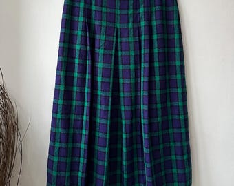 May include: A green and purple plaid skirt with pleats. The skirt is knee-length and has a straight silhouette.