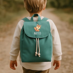 Peut inclure: Un sac à dos bleu sarcelle avec une fermeture à cordon et un rabat avec une illustration de renard et le nom Matteo.