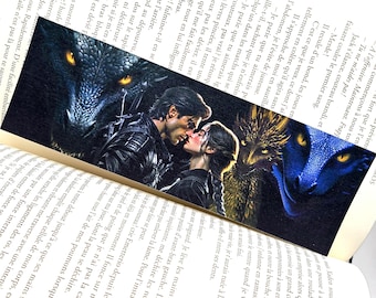 Op de afbeelding: Bladwijzer met een romantische fantasie scène met een kussend stel en drakenbeelden. De bladwijzer is rechthoekig en gemaakt van glanzend materiaal, voor boekenliefhebbers.