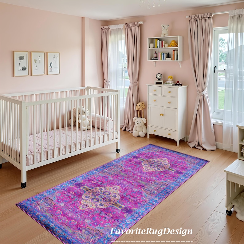 Puede incluir: Una alfombra de color rosa y morado con un dise&ntilde;o floral. La alfombra est&aacute; en una guarder&iacute;a con una cuna blanca y una c&oacute;moda blanca.