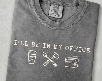 Camiseta de oficina para taller mecánico: diseño gráfico de café, herramientas y radio.