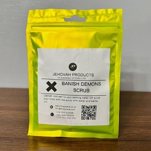 May include: A yellow pouch with a white label that reads "JEHOVAH PRODUCTS (A Subsidiary of FIHAJ LTD)" and "BANISH DEMONS SCRUB". The label also includes usage instructions, a website address, and contact information.