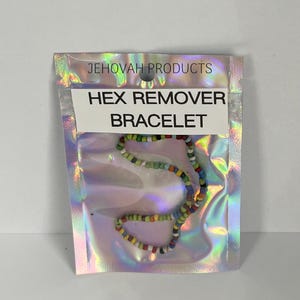 May include: A colorful beaded bracelet inside a holographic package. The package has the text "JEHOVAH PRODUCTS" at the top and "HEX REMOVER BRACELET" on a white label. The bracelet features a variety of small, round beads in multiple colors.