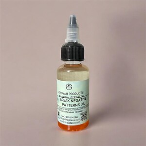 May include: A clear glass bottle with a black cap and a white and clear dropper. The bottle contains a light amber liquid with an orange base. The label reads "BREAK NEGATIVE PATTERNS OIL".