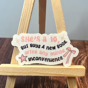 She’s a 10, But Buys a New Book After Any Minor Inconvenience - Holographic Sticker 2.5”