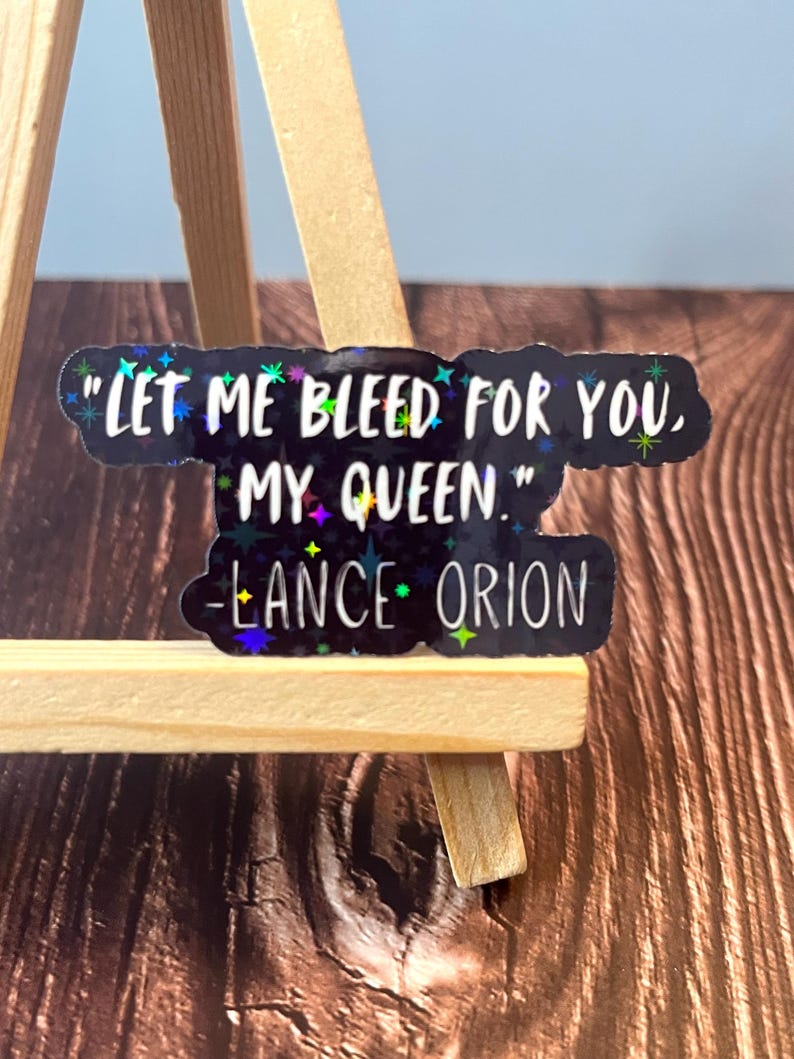 May include: A black sticker with iridescent glitter stars and the quote "Let me bleed for you, my queen." - Lance Orion.