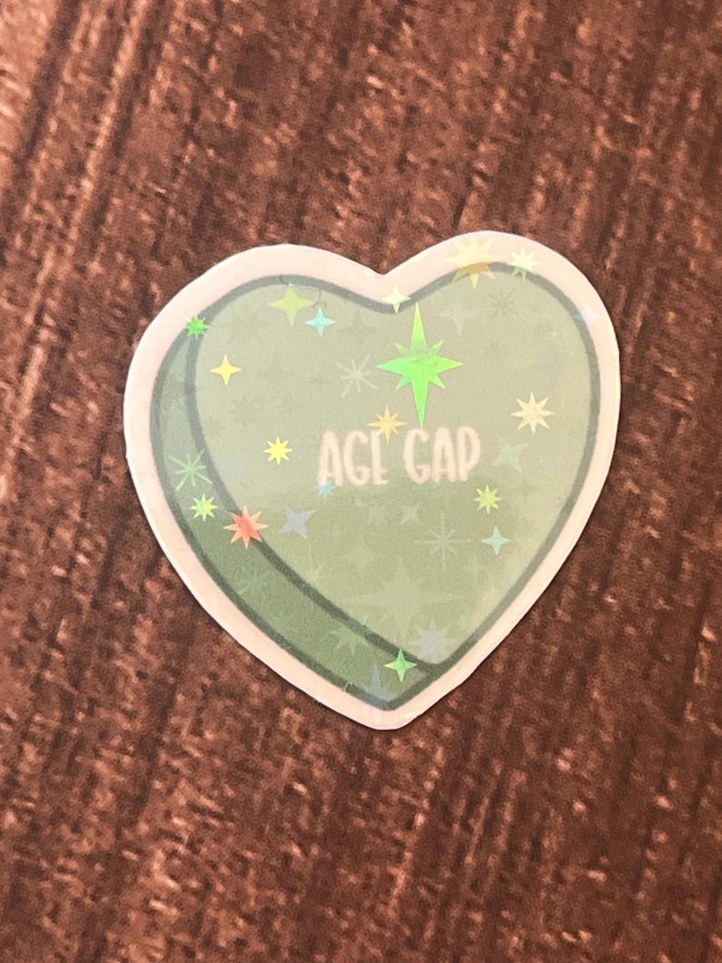May include: A green heart-shaped sticker with a glittery finish and the text "AGE GAP" in white.