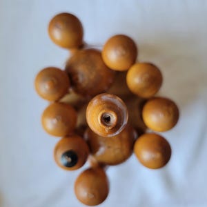 Puede incluir: Un juego de tapones de botella de madera en forma de pir&aacute;mide. Los tapones son de color marr&oacute;n claro y tienen una superficie lisa y redondeada.