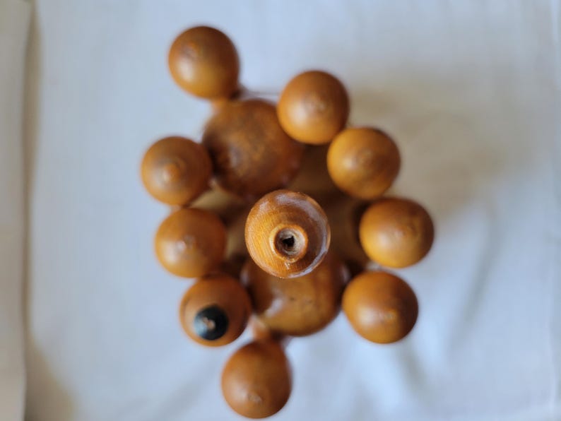Puede incluir: Un juego de tapones de botella de madera en forma de pir&aacute;mide. Los tapones son de color marr&oacute;n claro y tienen una superficie lisa y redondeada.