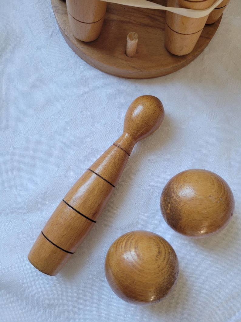 Antique Skittles Set for indoor carpet bowls games.

8 skittles, 2 balls, and a stand. 

Turned oak. 
Varnished.
Stand Height 25.5cm
Stand Width 14cm Dia
Skittle Height 15cm
Skittle Width 3cm
Ball Dia 5cm

Any questions please ask.