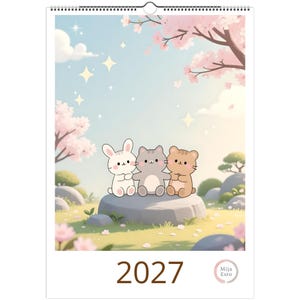 May include: A 2027 wall calendar featuring a pastel illustration of a white rabbit, a grey cat, and a brown bear sitting together on a stone. The scene includes cherry blossom trees, scattered petals, and sparkling stars in a light blue sky.