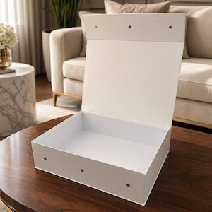 May include: A white rectangular storage box with an open hinged lid. The box features a smooth matte finish and three small circular metallic fasteners visible along the front edge of the base and three along the top edge of the lid.