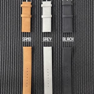 May include: Six faux leather watch straps in sand, grey, and black. Each strap has a silver buckle and is labeled with its color. The bottom row of straps is labeled "FAUX LEATHER".