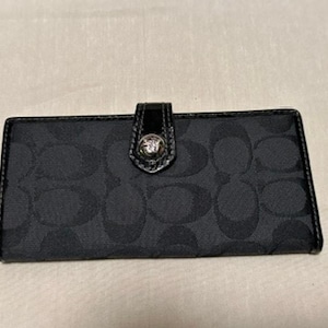 Cartera auténtica de tela con monograma de la firma Coach en color negro