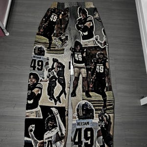May include: Tapestry pants featuring a collage of football player images, including the number 49. The color palette includes black, white, gray, and tan. The pants are a unique, artistic piece.
