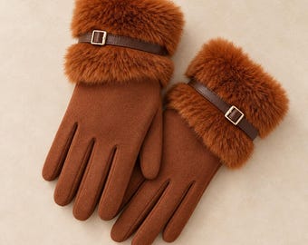 May include: A pair of brown gloves featuring a soft, fuzzy faux fur cuff at the wrist. Each glove is accented with a thin, dark brown strap that wraps around the cuff, secured by a small, rectangular gold-toned metal buckle.