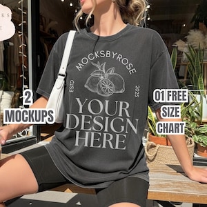 May include: A dark gray t-shirt with the text "YOUR DESIGN HERE" and a lemon graphic. The shirt also has the text "MOCKSBYROSE" and "ESTD 2025". The image also includes the text "2 MOCKUPS" and "01 FREE SIZE CHART".