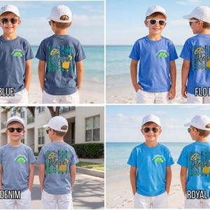 May include: Four short-sleeved t-shirts in shades of blue are displayed. Each shirt features a graphic on the front and back. The back graphics include the word "Rose" and a cocktail design. The shirts are labeled "China Blue", "Flo Blue", "Washed Denim", and "Royal Caribe".