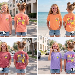May include: Four t-shirts in terracotta, melon, crimson, and violet. Each shirt has a graphic on the front and back. The back graphic says "Rose" with a lemon and palm tree design. The shirts are worn by young girls with sunglasses.